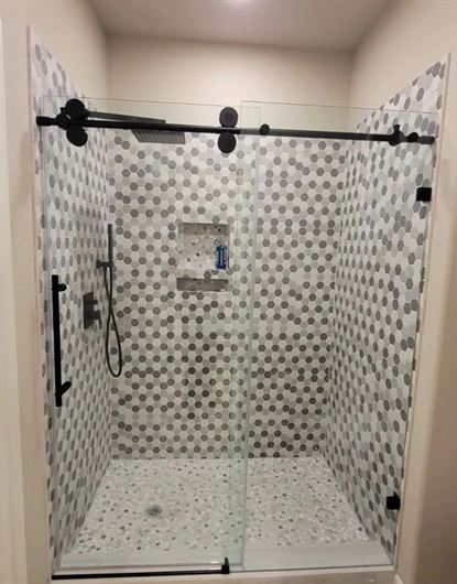 Frameless sliding shower door with large rollers installed in a Pembroke Pines, FL home